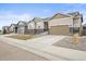 Street view of homes with well-manicured lawns, two car garages, and stone accents at 7268 Greenwater Cir, Castle Rock, CO 80108