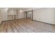 Spacious basement area with wood floors, white walls, recessed lights, with a built in shelving unit and an open entry space at 13486 Clayton St, Thornton, CO 80241