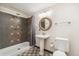 This bathroom features a pedestal sink, custom shower and tile flooring, with a decorative mirror and modern lighting at 13486 Clayton St, Thornton, CO 80241