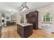 Open kitchen featuring brown cabinets, granite counters, hardwood floors, and decorative lighting at 13486 Clayton St, Thornton, CO 80241