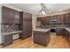 Modern kitchen featuring rich brown cabinets, stainless steel appliances and hardwood floors at 13486 Clayton St, Thornton, CO 80241