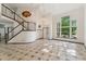 Bright living room with tile flooring, stairs to the upper level and many large windows at 13486 Clayton St, Thornton, CO 80241