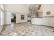Open-concept living room featuring tile flooring, stairs to the upper level and an open doorway at 13486 Clayton St, Thornton, CO 80241