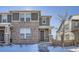 Two-story brick home with gray accents, snowy front yard, and a walkway leading to the front door at 16630 E Virginia Ave, Aurora, CO 80017