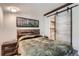 Bright bedroom with a wooden accent headboard and a stylish sliding barn door to the bathroom at 1701 Kingston St, Aurora, CO 80010