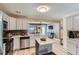 Spacious kitchen with stainless steel appliances, a breakfast bar, and easy access to the living room at 1701 Kingston St, Aurora, CO 80010