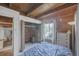 Cozy bedroom features natural light, closet space and warm wood paneling with a wooden ceiling at 1020 Kipling St, Lakewood, CO 80215