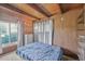 Bedroom with a wooden ceiling, wood paneled walls, filled with natural light, and closet space at 1020 Kipling St, Lakewood, CO 80215