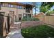 Exterior of home with a landscaped backyard featuring a stone patio and flowerbeds at 1703 S Grant S St, Denver, CO 80210