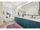 Modern bathroom with dual sinks, a soaking tub, large mirror, and stylish blue cabinets at 1703 S Grant S St, Denver, CO 80210