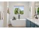 Bright bathroom featuring a modern soaking tub, elegant fixtures, and stylish vanity at 1703 S Grant S St, Denver, CO 80210