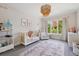 This staged bedroom offers a crib, plush rug, and natural light from the window at 1703 S Grant S St, Denver, CO 80210