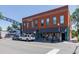 Two-story brick building with awnings over storefronts and cars parked along the street at 1703 S Grant S St, Denver, CO 80210