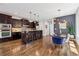 Open kitchen with dark cabinets, breakfast bar, and stainless steel appliances, with dining area at 1703 S Grant S St, Denver, CO 80210