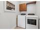 This bright laundry room features a washer, dryer, cabinet, and hanging rack at 1703 S Grant S St, Denver, CO 80210