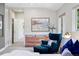 Cozy main bedroom featuring soft lighting, accent chair, and a view to an adjacent room at 1703 S Grant S St, Denver, CO 80210