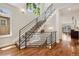 Modern staircase with metal railing and hardwood floors offer a bright and airy feel at 1703 S Grant S St, Denver, CO 80210