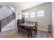 Dining area featuring a dark wood table, bench seating, and a modern chandelier at 21574 E 59Th Dr, Aurora, CO 80019