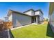 Rear exterior view of a modern home featuring a well-kept lawn and outdoor patio at 21574 E 59Th Dr, Aurora, CO 80019