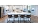 Modern kitchen features a large island with seating, stainless steel appliances, and sleek white cabinetry at 21574 E 59Th Dr, Aurora, CO 80019