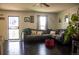 Cozy living room featuring dark hardwood floors, a comfortable sectional sofa, and ample natural light at 19930 E Cornell Ave, Aurora, CO 80013