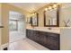 Elegant bathroom featuring double vanities and mirrors, tiled floors and a doorway to a living space at 2950 Wyecliff Ln, Highlands Ranch, CO 80126