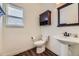Well-lit half bathroom featuring wood-look floors and white pedestal sink, enhancing the home's appeal at 2950 Wyecliff Ln, Highlands Ranch, CO 80126
