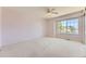 Large bedroom has neutral carpet, a ceiling fan, and a window overlooking the yard at 2950 Wyecliff Ln, Highlands Ranch, CO 80126