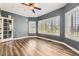 Spacious bedroom featuring hardwood floors, large windows with shutters, and a ceiling fan at 2950 Wyecliff Ln, Highlands Ranch, CO 80126