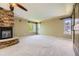Large bedroom with stone fireplace, tray ceilings, a ceiling fan, and wide windows at 2950 Wyecliff Ln, Highlands Ranch, CO 80126