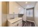 Laundry room with ample cabinet space, a sink, and natural light at 2950 Wyecliff Ln, Highlands Ranch, CO 80126