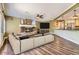 Open living space with stone fireplace, hardwood floors, modern furniture, and seamless flow into kitchen at 2950 Wyecliff Ln, Highlands Ranch, CO 80126