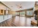 Open living room with a stone fireplace, fan, and hardwood floors seamlessly connected to the kitchen at 2950 Wyecliff Ln, Highlands Ranch, CO 80126
