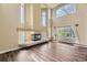Spacious living room with soaring ceilings, large windows, fireplace, and attractive flooring at 2950 Wyecliff Ln, Highlands Ranch, CO 80126