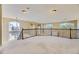 Spacious loft area with carpet, large windows providing ample natural light, and decorative railing at 2950 Wyecliff Ln, Highlands Ranch, CO 80126