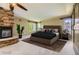 Cozy bedroom featuring a stone fireplace, ceiling fan and sliding barn door at 2950 Wyecliff Ln, Highlands Ranch, CO 80126