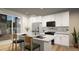 Modern kitchen with stainless steel appliances, center island with seating, and sleek white cabinetry at 46541 Sunflower Ln, Bennett, CO 80102