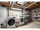 Unfinished basement laundry room with modern washer and dryer units and ample shelving for storage at 6869 S Niagara Ct, Centennial, CO 80112