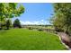 Lush backyard with manicured lawn, featuring a charming fence and golf course views, perfect for outdoor relaxation at 12015 Blackwell Way, Parker, CO 80138