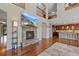 Open-concept living room showcasing a stone fireplace and seamless flow to the kitchen at 12015 Blackwell Way, Parker, CO 80138