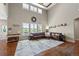 Bright living room with vaulted ceilings, a leather sectional, and oversized windows at 12015 Blackwell Way, Parker, CO 80138