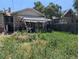 The backyard view shows an overgrown yard with an aging, covered patio at 1415 Raleigh St, Denver, CO 80204