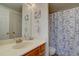 This bathroom offers a sink, vanity and toilet with patterned shower curtain at 11115 E Alameda Ave # 201, Aurora, CO 80012