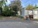 View of the garage from a rear angle with an unkempt yard featuring some discarded items and a gray exterior at 36 N Logan St, Denver, CO 80203