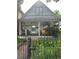 Charming home featuring a covered front porch with comfortable seating and a blossoming garden at 36 N Logan St, Denver, CO 80203