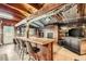 Rustic bar area featuring wooden bar with seating, fireplace, and corrugated metal ceiling at 6646 S Fundy Ct, Centennial, CO 80016