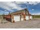 Rustic barn featuring multiple garage doors and a weathered exterior, set against a blue sky at 6646 S Fundy Ct, Centennial, CO 80016