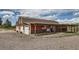 Charming barn with a rustic aesthetic, featuring multiple bays, a porch, and an American flag at 6646 S Fundy Ct, Centennial, CO 80016