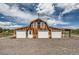 Rustic barn featuring multiple garage doors and a weathervane, set against a blue sky with puffy clouds at 6646 S Fundy Ct, Centennial, CO 80016
