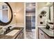 Elegant bathroom featuring dual vanities, wainscoting, stylish fixtures, and walk in shower at 6646 S Fundy Ct, Centennial, CO 80016